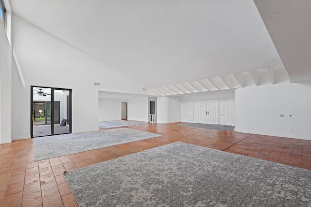 unfurnished living room featuring high vaulted ceiling, visible vents, and baseboards