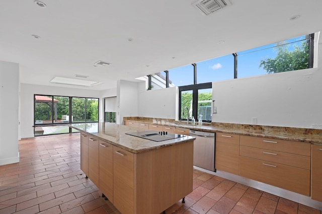 kitchen featuring visible vents, dishwasher, modern cabinets, a center island, and light brown cabinetry