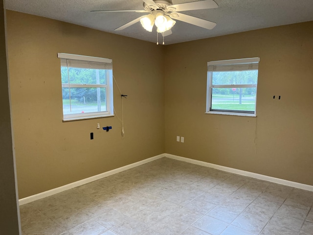 empty room featuring ceiling fan and a textured ceiling