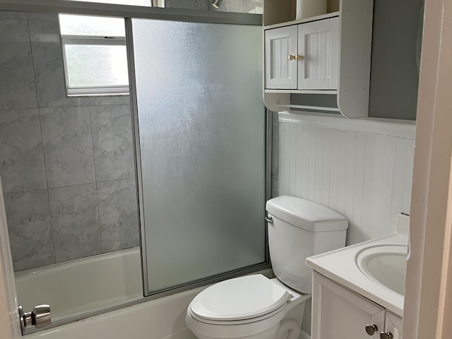 full bathroom featuring vanity, toilet, and bath / shower combo with glass door