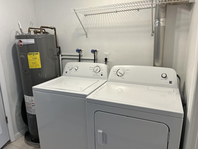 laundry room featuring light tile patterned flooring, washing machine and dryer, and water heater