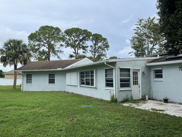 back of property with a yard and a patio area