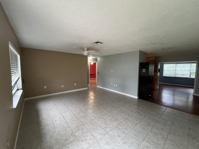 unfurnished room with a textured ceiling and ceiling fan