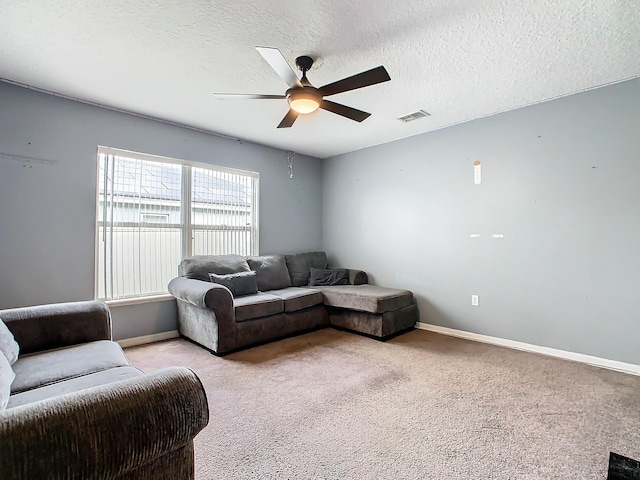 carpeted living room with a textured ceiling and ceiling fan