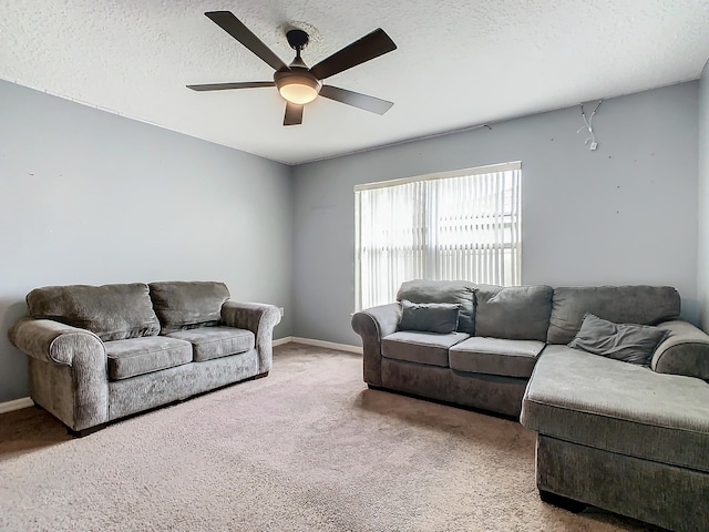 carpeted living room featuring ceiling fan and a textured ceiling