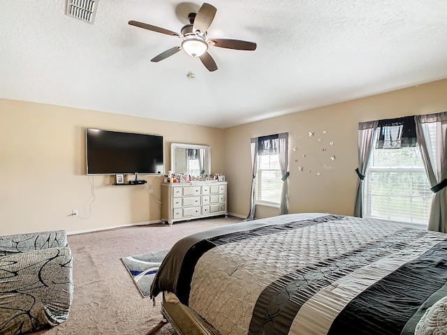 bedroom with light carpet, a textured ceiling, and ceiling fan