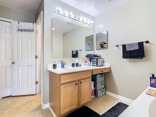 bathroom with a textured ceiling, vanity, and tile patterned floors