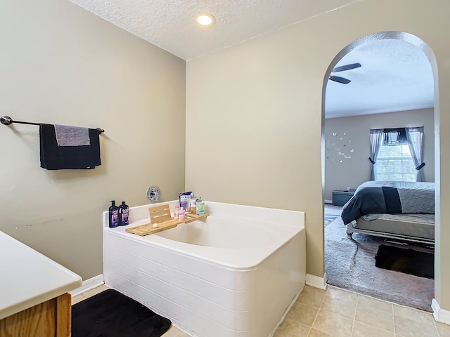 bathroom featuring a textured ceiling, a bath, and tile patterned floors