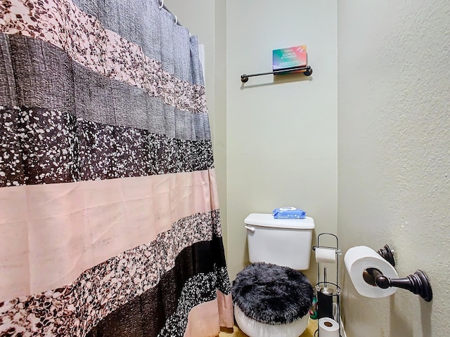 bathroom featuring a shower with curtain and toilet