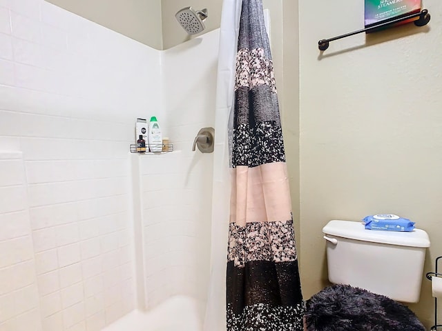 bathroom featuring toilet and a shower with curtain