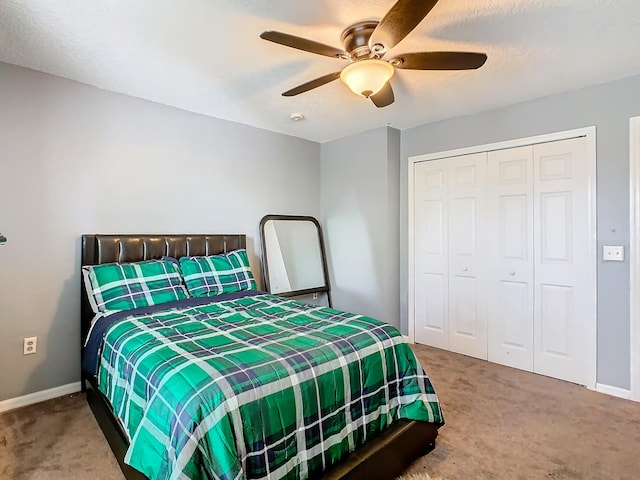 carpeted bedroom with ceiling fan and a closet