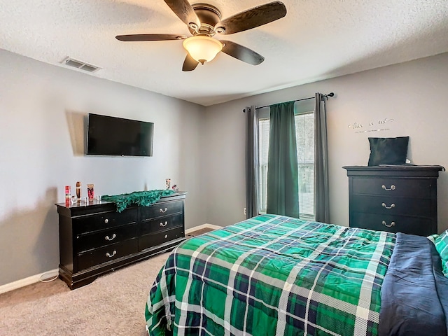 bedroom featuring a textured ceiling, ceiling fan, and carpet floors