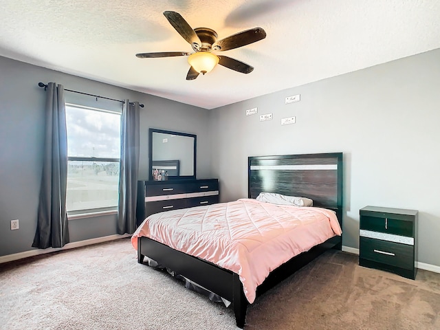 carpeted bedroom featuring ceiling fan and a textured ceiling