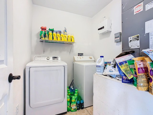 clothes washing area featuring light tile patterned floors and washer and dryer