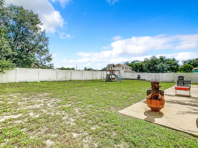 view of yard with a playground, a fire pit, and a patio area