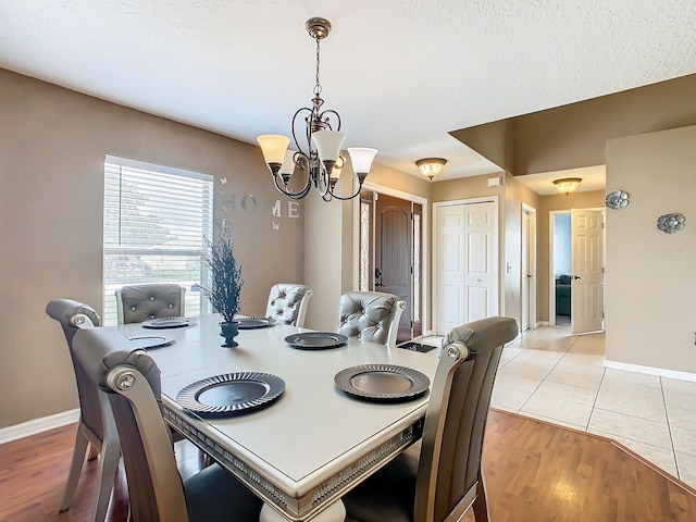 dining area with an inviting chandelier and light hardwood / wood-style flooring