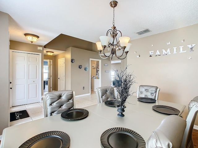 tiled dining room featuring an inviting chandelier