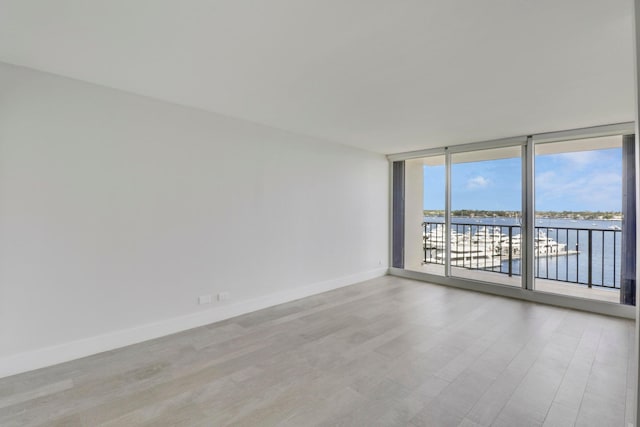 spare room featuring light hardwood / wood-style floors and a water view