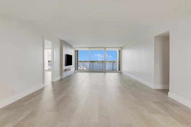 unfurnished living room with light hardwood / wood-style flooring and floor to ceiling windows