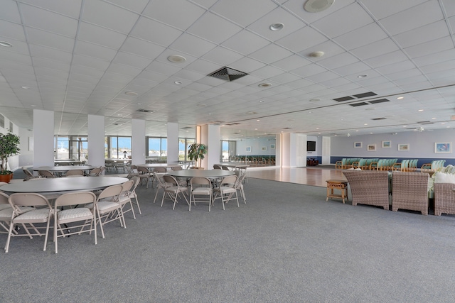 dining space featuring carpet floors and a drop ceiling