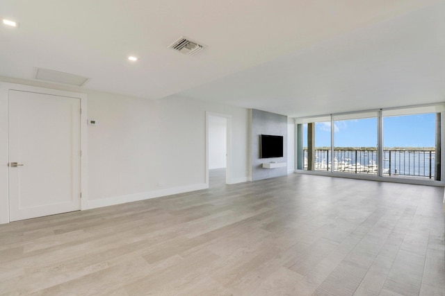 unfurnished living room featuring light wood-type flooring and expansive windows