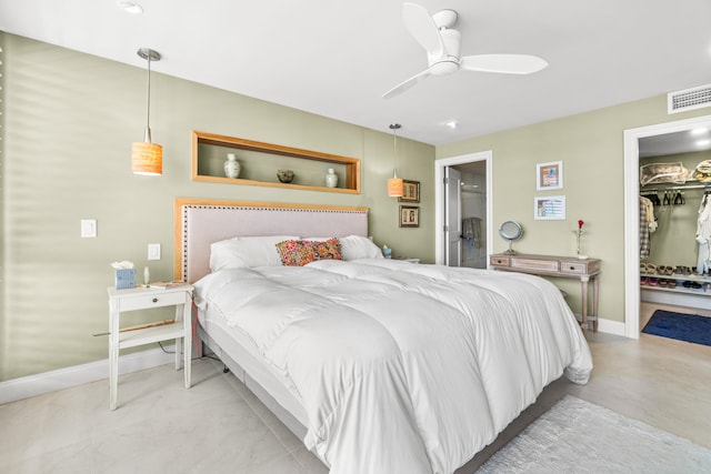 bedroom with a closet, ceiling fan, a spacious closet, and ensuite bath