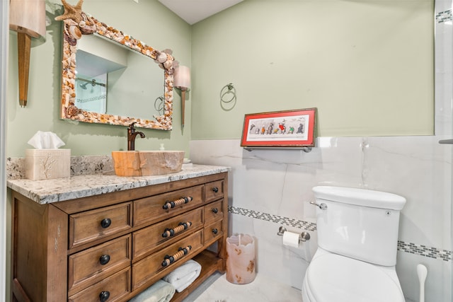 bathroom featuring tile walls, toilet, and vanity