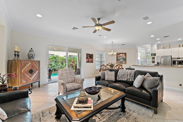 tiled living room with a textured ceiling, ceiling fan with notable chandelier, ornamental molding, and a wealth of natural light