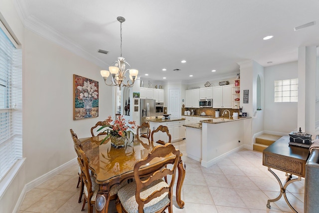 dining space featuring crown molding, an inviting chandelier, light tile patterned floors, and sink