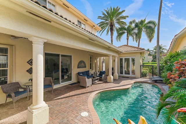 view of pool with outdoor lounge area, a patio area, and french doors