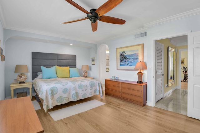 bedroom featuring ceiling fan, crown molding, and light wood-type flooring