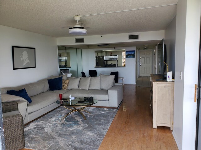 living room with wood-type flooring and a textured ceiling