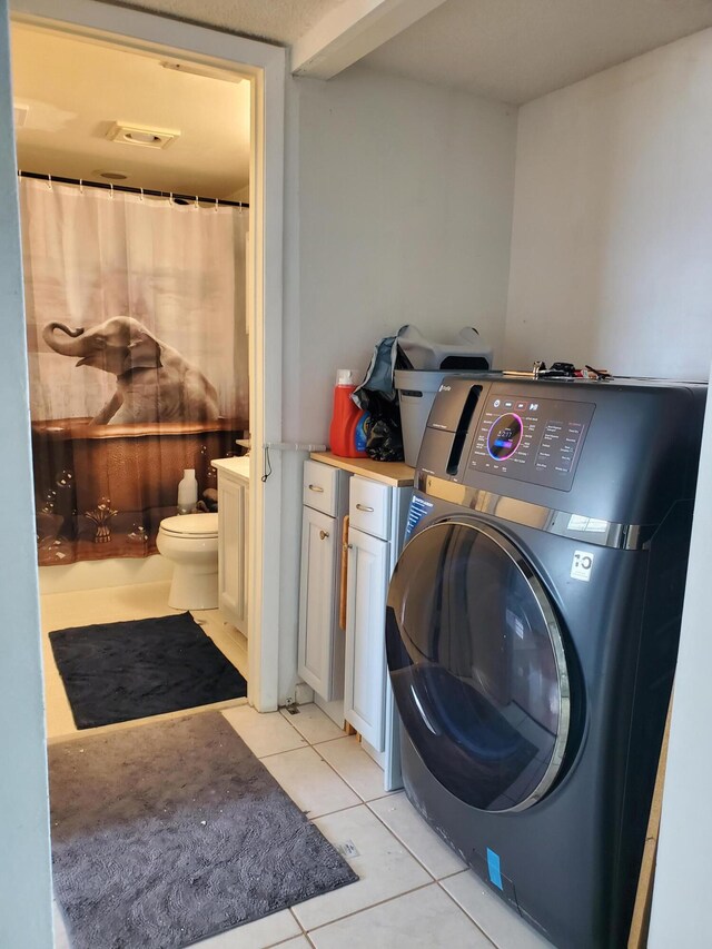 washroom featuring washer / clothes dryer and light tile patterned floors