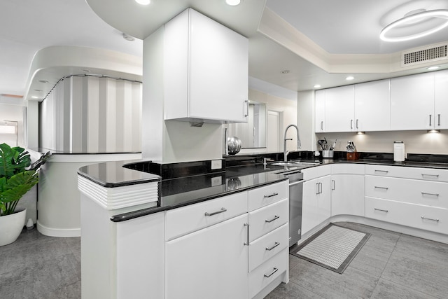 kitchen featuring kitchen peninsula, white cabinetry, and sink