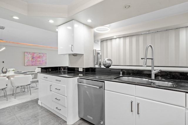 kitchen with white cabinets, dark stone countertops, sink, and stainless steel dishwasher