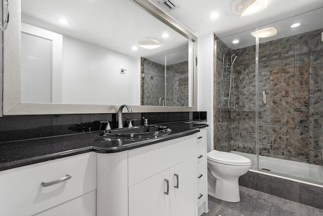 bathroom featuring an enclosed shower, toilet, and vanity