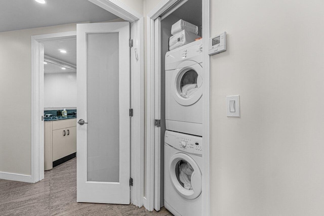 clothes washing area with stacked washer and clothes dryer