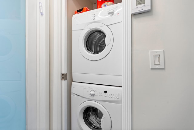 clothes washing area with stacked washer and clothes dryer