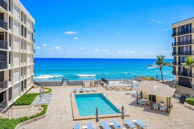 view of pool with a water view and a patio