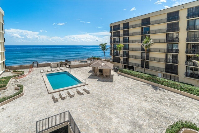 view of pool with a water view and a patio