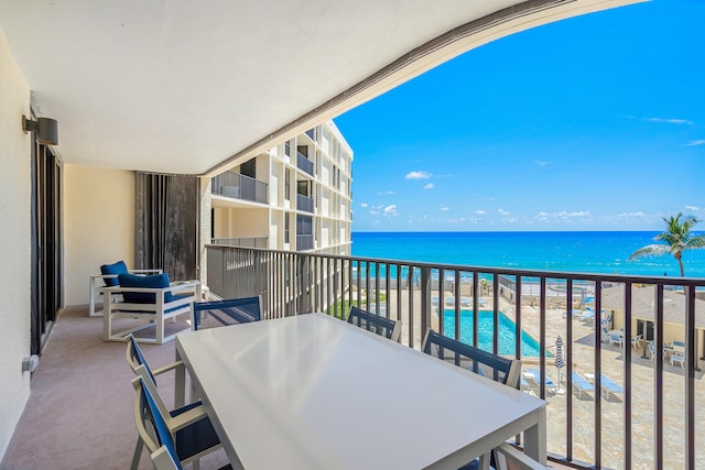 balcony featuring a water view and a view of the beach