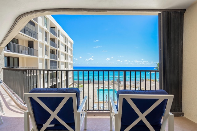 balcony featuring a water view and a beach view