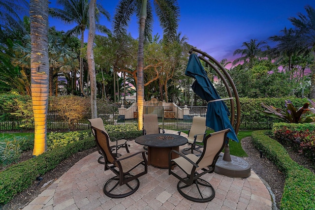 patio terrace at dusk featuring an outdoor fire pit