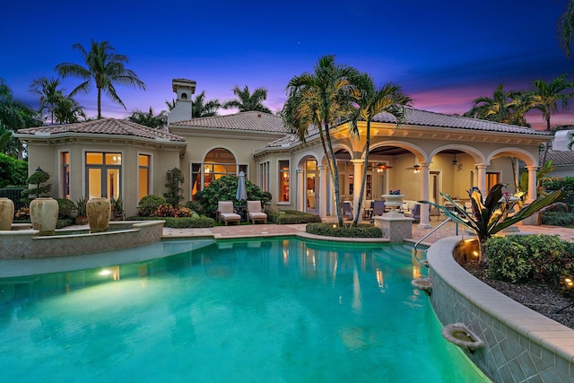 back house at dusk featuring a patio and french doors