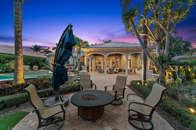 patio terrace at dusk featuring a fire pit