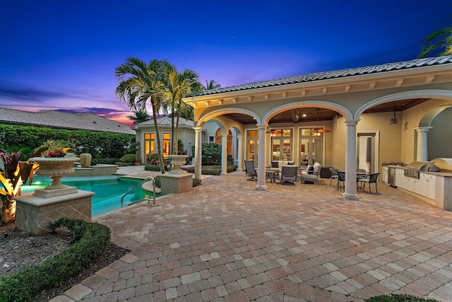 pool at dusk with area for grilling, a patio area, and french doors