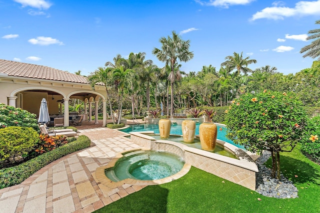 view of pool with an in ground hot tub, a yard, and a patio area