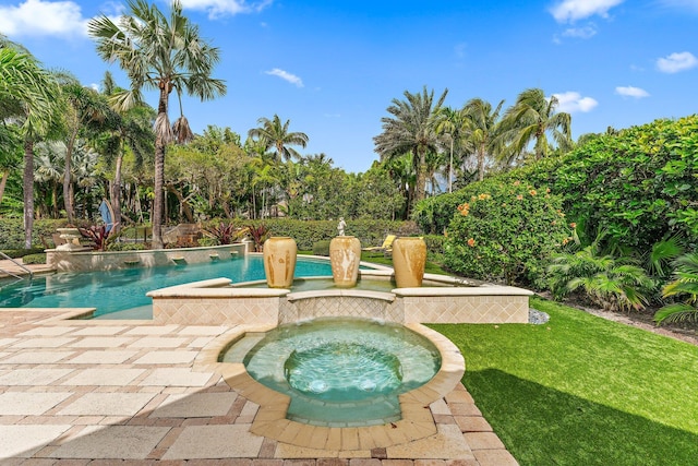 view of swimming pool featuring a lawn and an in ground hot tub