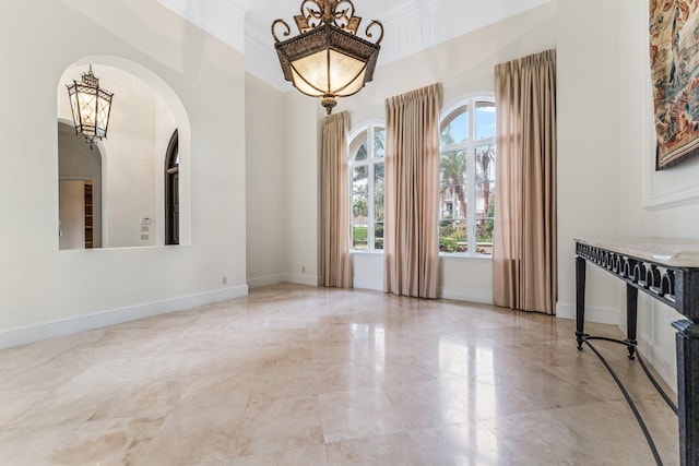 unfurnished room with crown molding and a chandelier