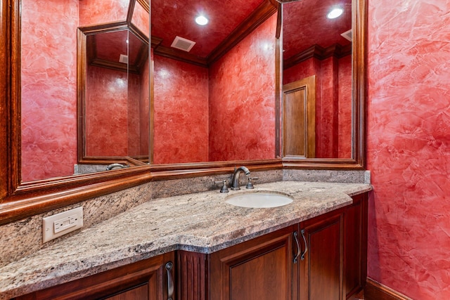 bathroom with ornamental molding and vanity